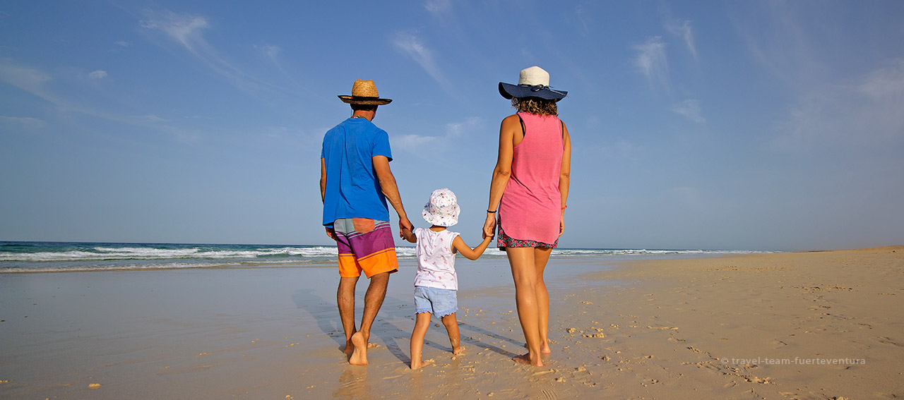 Una familia paseando en las grandes playas de Corralejo.